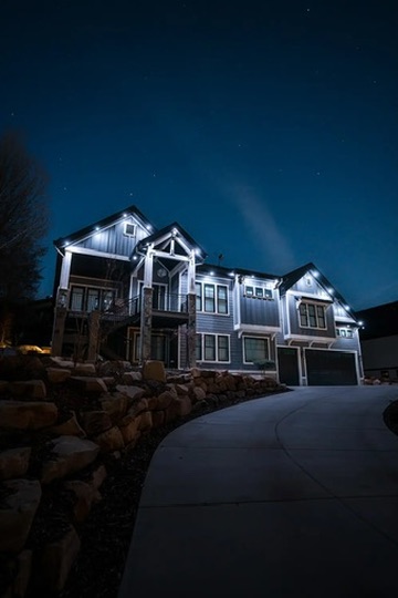 Permanent exterior lighting installation on a home at night, Gallatin Valley